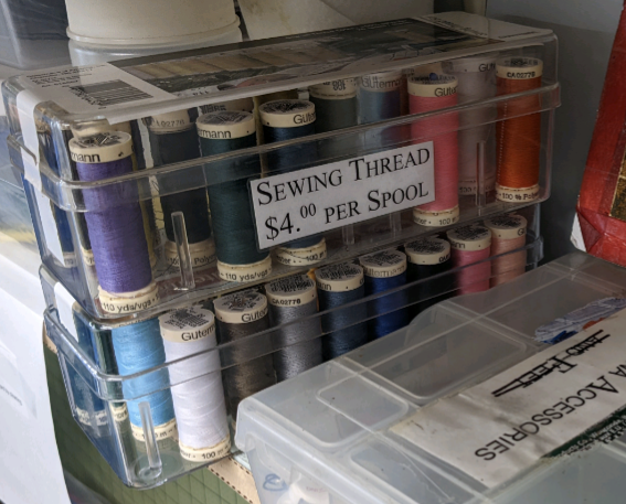 box of sewing thread with recommended contribution of $4 per spool